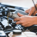 Luxury car maintenance - mechanic performing an oil change