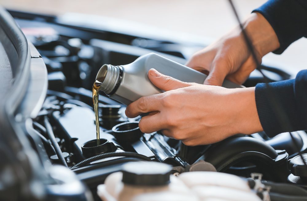 Luxury car maintenance - mechanic performing an oil change